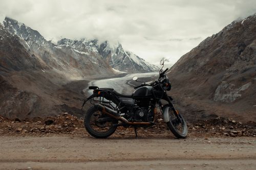 Free Motorcycle parked on a scenic dirt road in the Himalayas, India, perfect for adventure enthusiasts. Stock Photo
