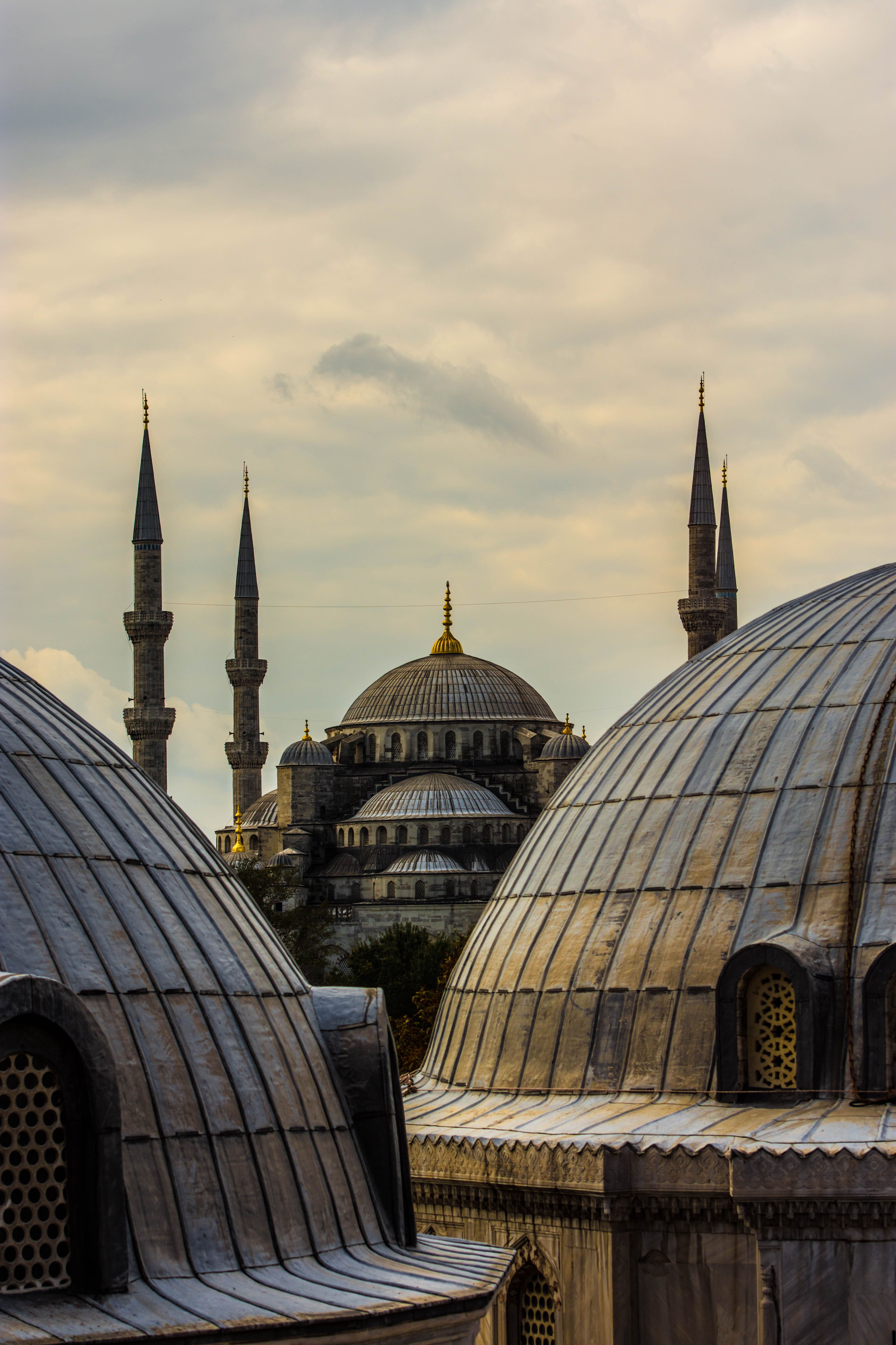 Dramatic view of the Blue Mosque in Istanbul at sunset, showcasing Ottoman architecture.