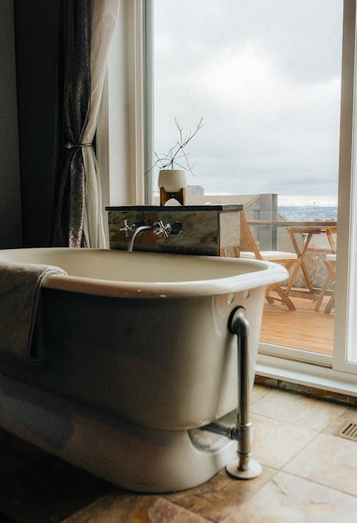 A Bathtub near a Window with View of the Terrace 