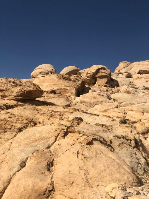 Free Bright sunlit rock formations showcasing a desert landscape under a clear blue sky. Stock Photo