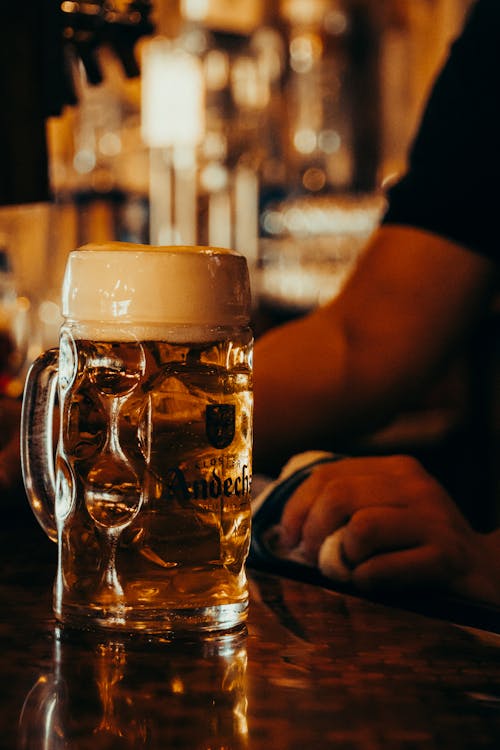 Man Hand near Glass of Beer
