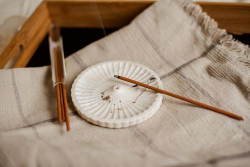 Free Minimalist incense setup with wooden holder and textured fabric for a calming ambience. Stock Photo