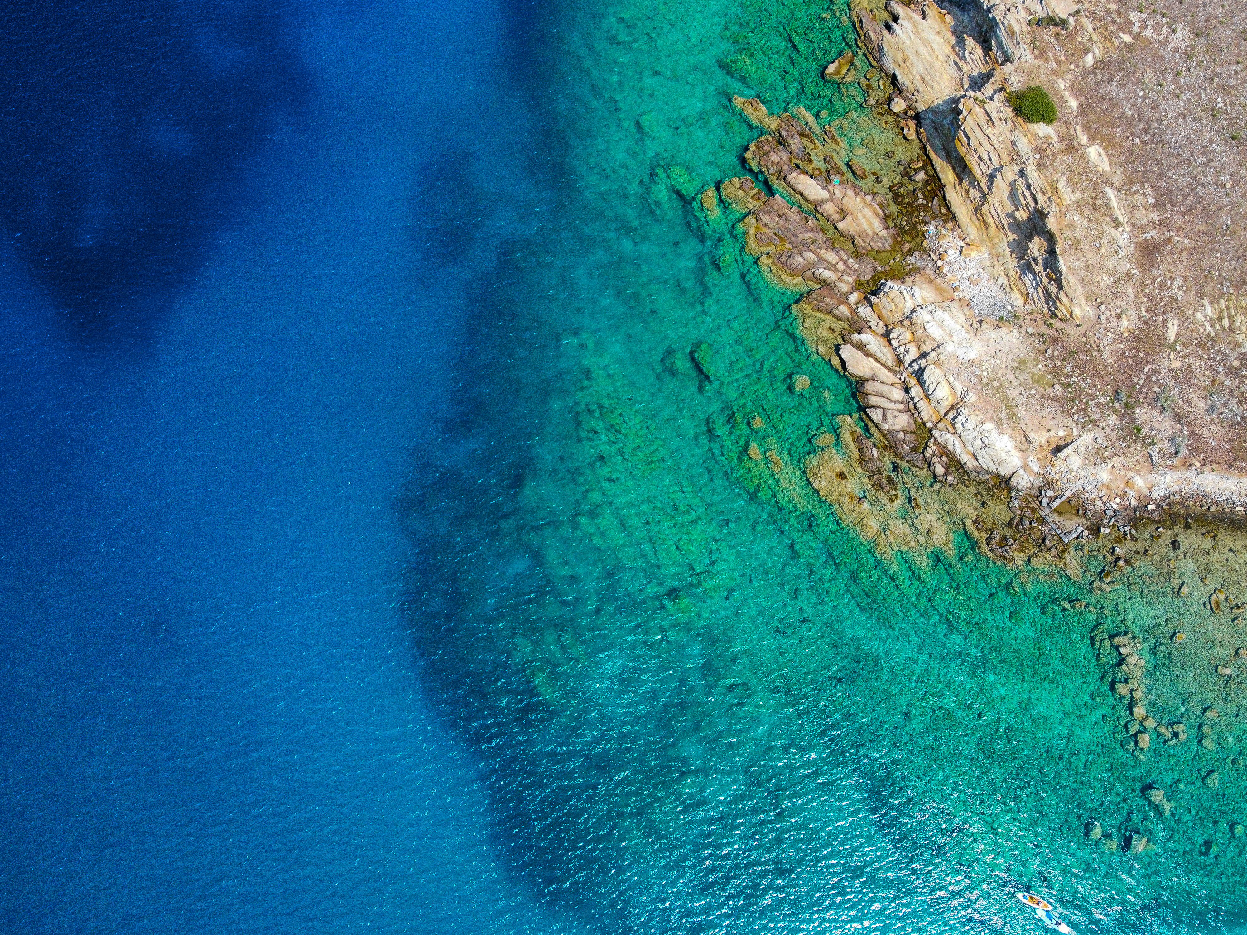 Aerial View of the Turquoise Sea and a Rocky Coast · Free Stock Photo