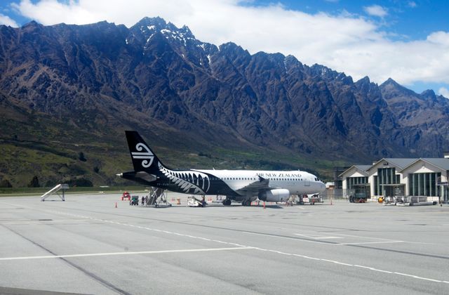 Air New Zealand plane at Queenstown Airport with stunning mountain backdrop. — arriving in Queenstown