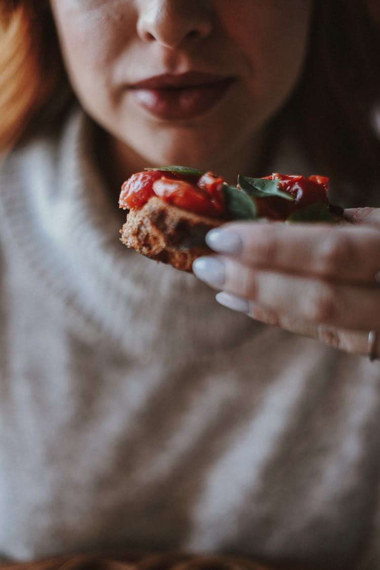 Eating A Sandwich With Tomatoes And Basil