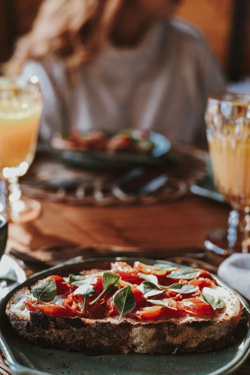 Free A close-up of a gourmet toast topped with fresh tomatoes and greens, ideal for breakfast scenes. Stock Photo