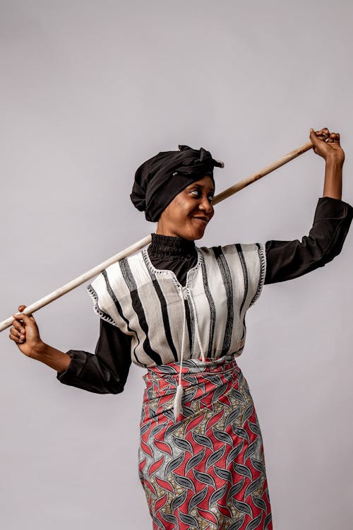 Studio Portrait of a Woman Wearing Traditional Clothes Holding a Pole