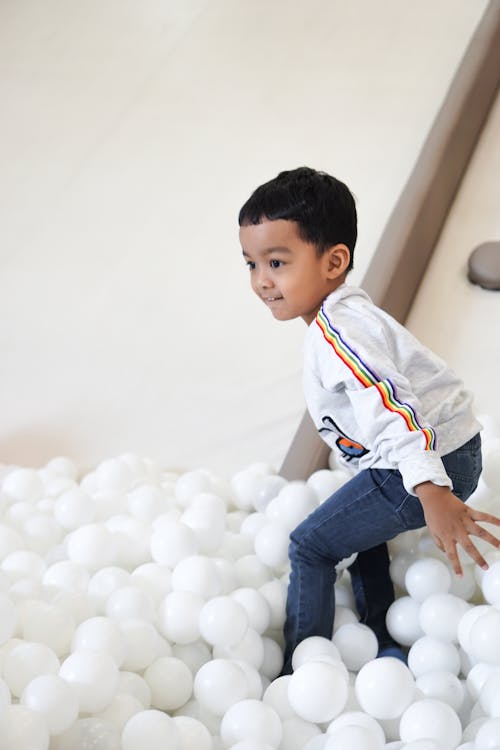 A Toddler Playing in a Ball Pit 