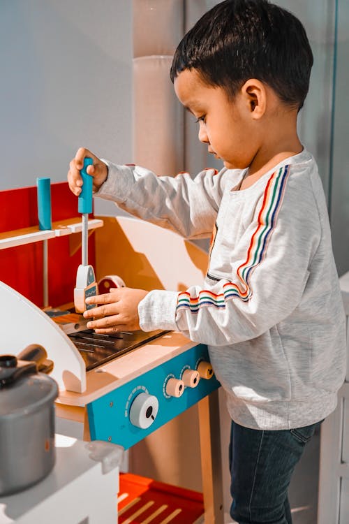 A Toddler Playing with a Mini Kitchen Set