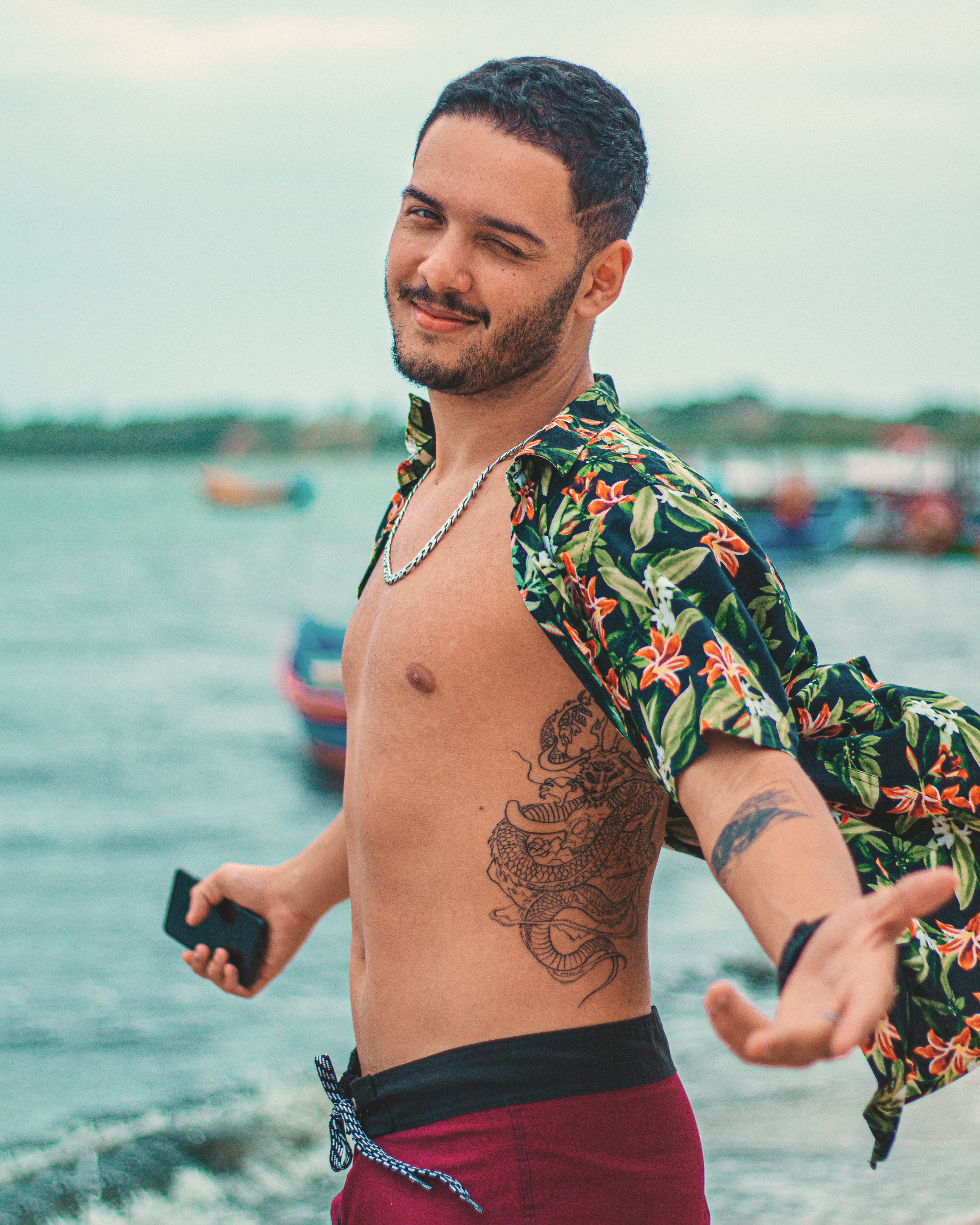 Man in a tropical shirt enjoying a casual day at the seashore, embracing summer vibes.