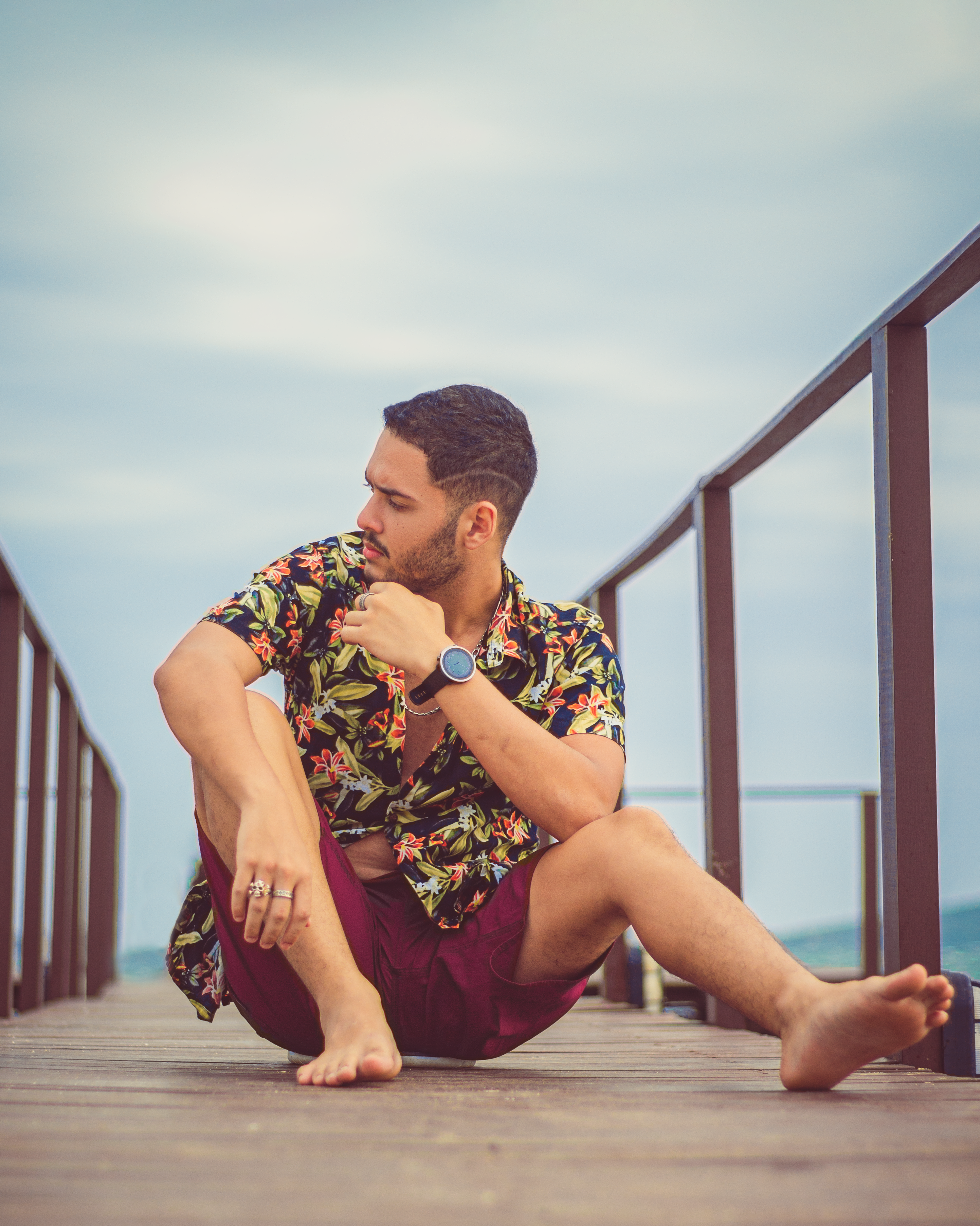 Man in Shorts and a Hawaiian Shirt Sitting on a Pier · Free Stock Photo
