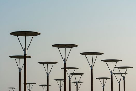 Artistic capture of modern streetlights silhouetted against a twilight sky.