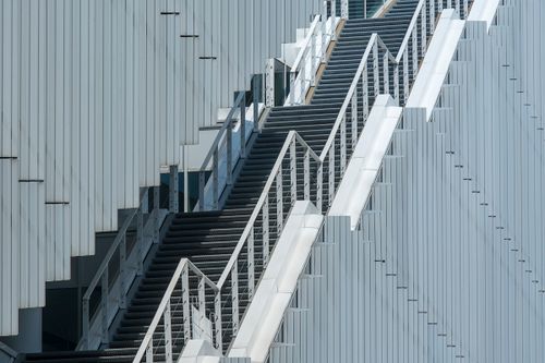 Free Sleek metal staircase against a modern building facade in an urban environment. Stock Photo