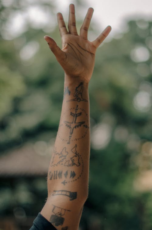 Close-up of a Tattooed Arm of a Man Held in the Air 