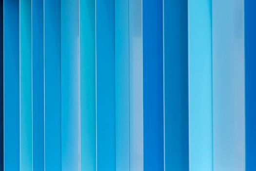 Vibrant abstract blue metal facade with vertical patterns, ideal for backgrounds.