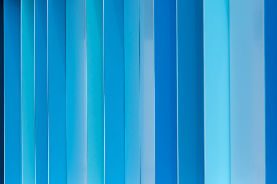 Vibrant abstract blue metal facade with vertical patterns, ideal for backgrounds.