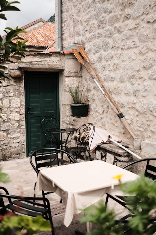 Free Cozy rustic patio with stone walls and vintage chairs in Kotor, Montenegro. Stock Photo