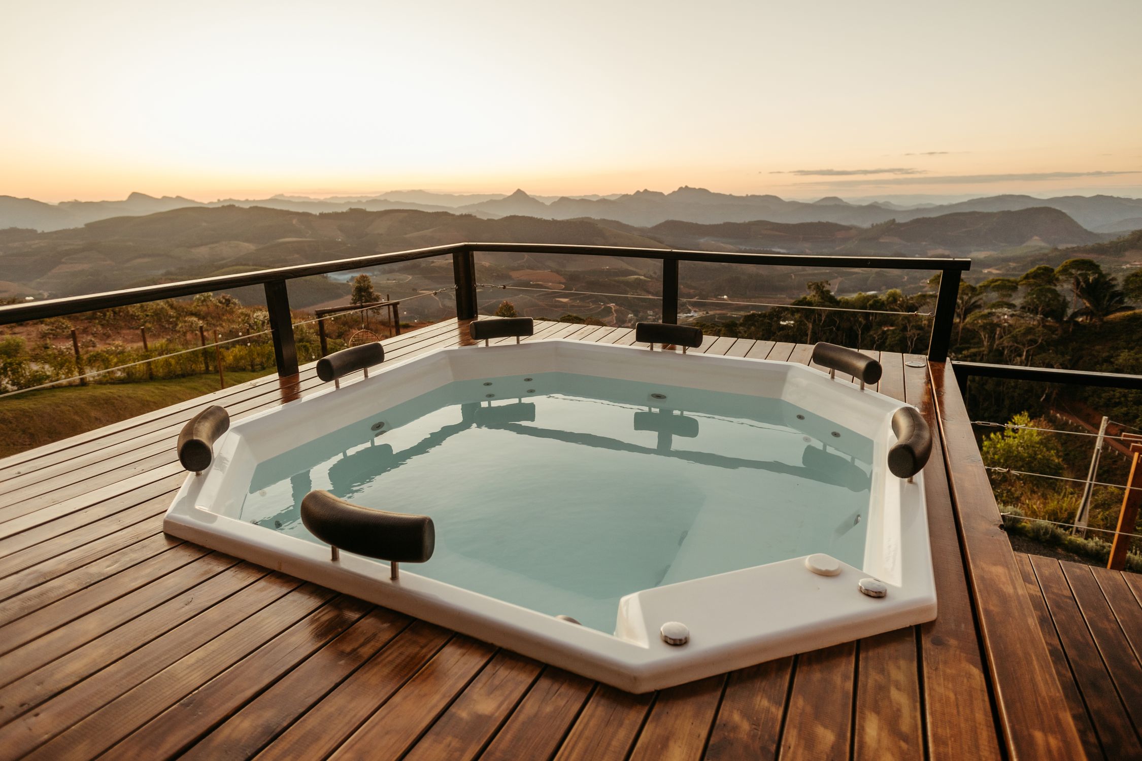 Relaxing hot tub with stunning mountain view at sunset, perfect for luxury retreats.
