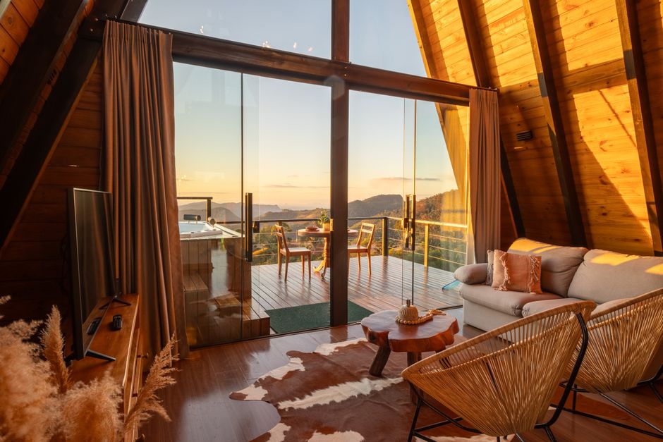 Warm rustic A-frame interior with a scenic view terrace, perfect for relaxation.