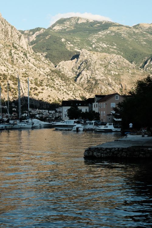 Free A breathtaking view of Kotor Bay with mountains and sailboats at sunset, perfect for travel enthusiasts. Stock Photo