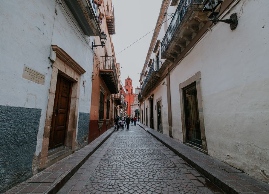 Picturesque cobblestone street in Guanajuato, Mexico showcasing colonial architecture.