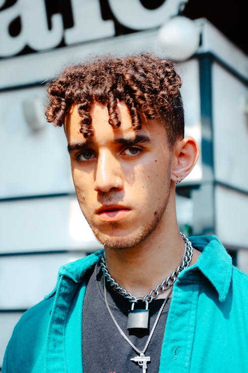 Portrait of a Young Man with Curly Hair Standing Outside 