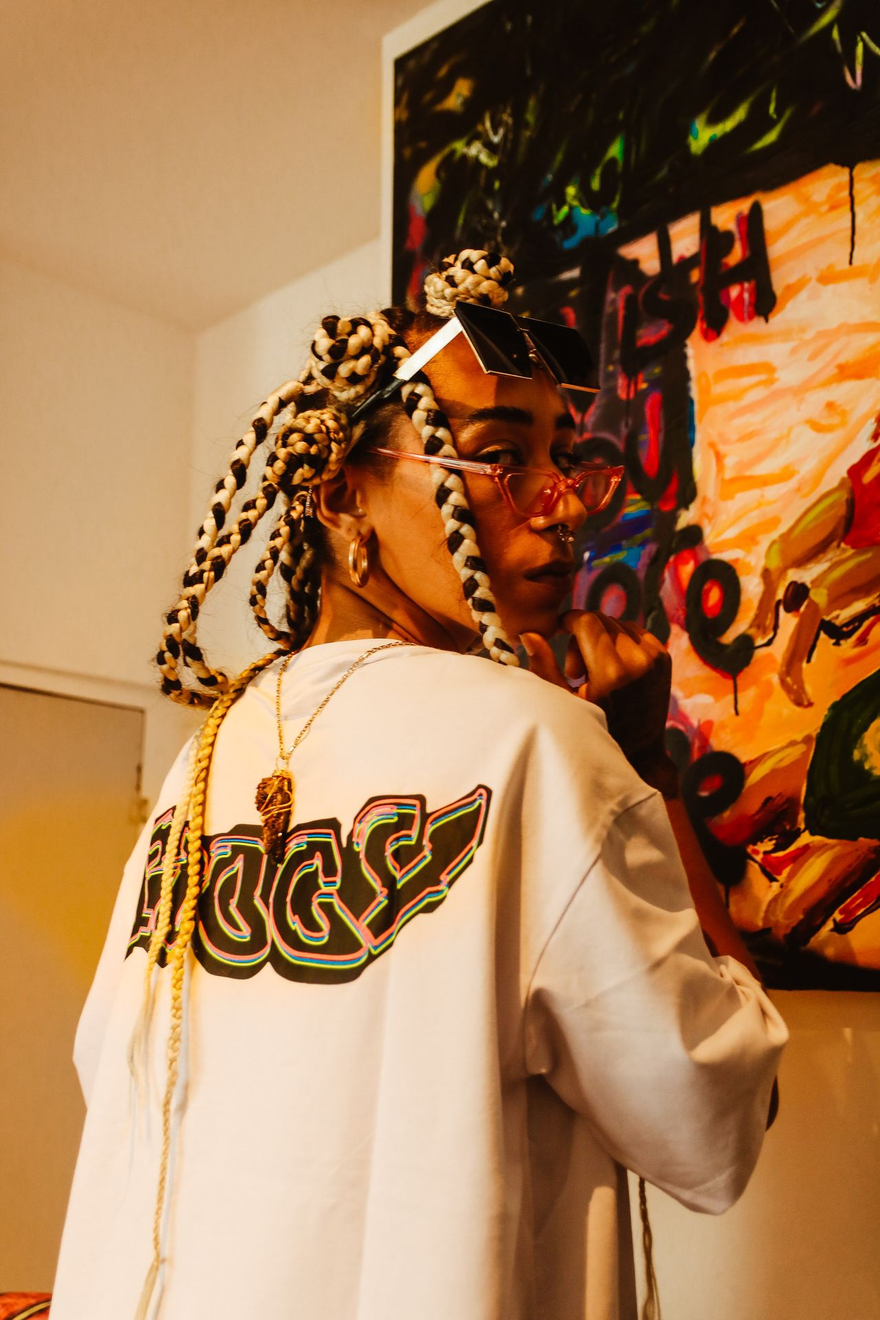 Woman with braided hair wearing an oversized white graphic tee