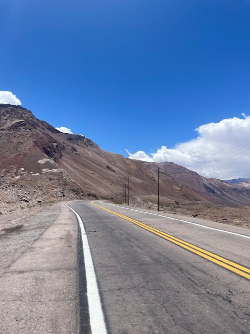 Kostnadsfri bild av asfalt, bergen, blå himmel