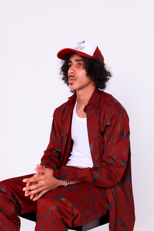 Man Sitting in Cap and Red Clothes
