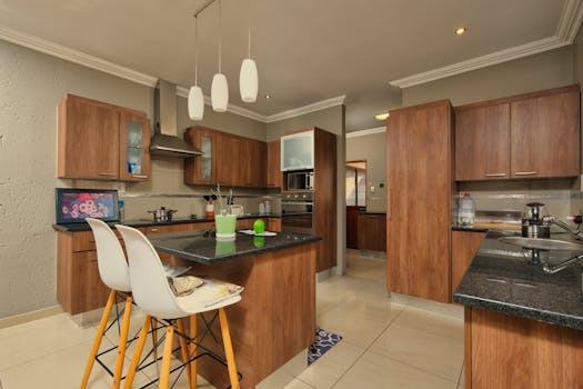 Spacious modern kitchen featuring wooden cabinets and stylish interior design.