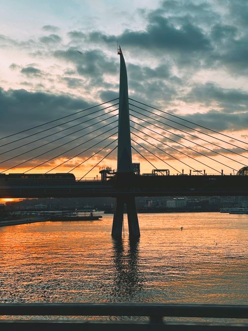 Free Silhouette of the Golden Horn Bridge at sunset in Istanbul with stunning reflections on the water. Stock Photo