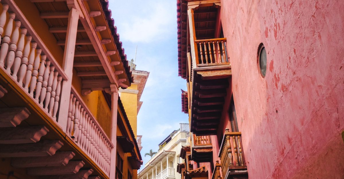 Colorful narrow street with balconies in Cartagena, Colombia, highlighting vibrant architecture.