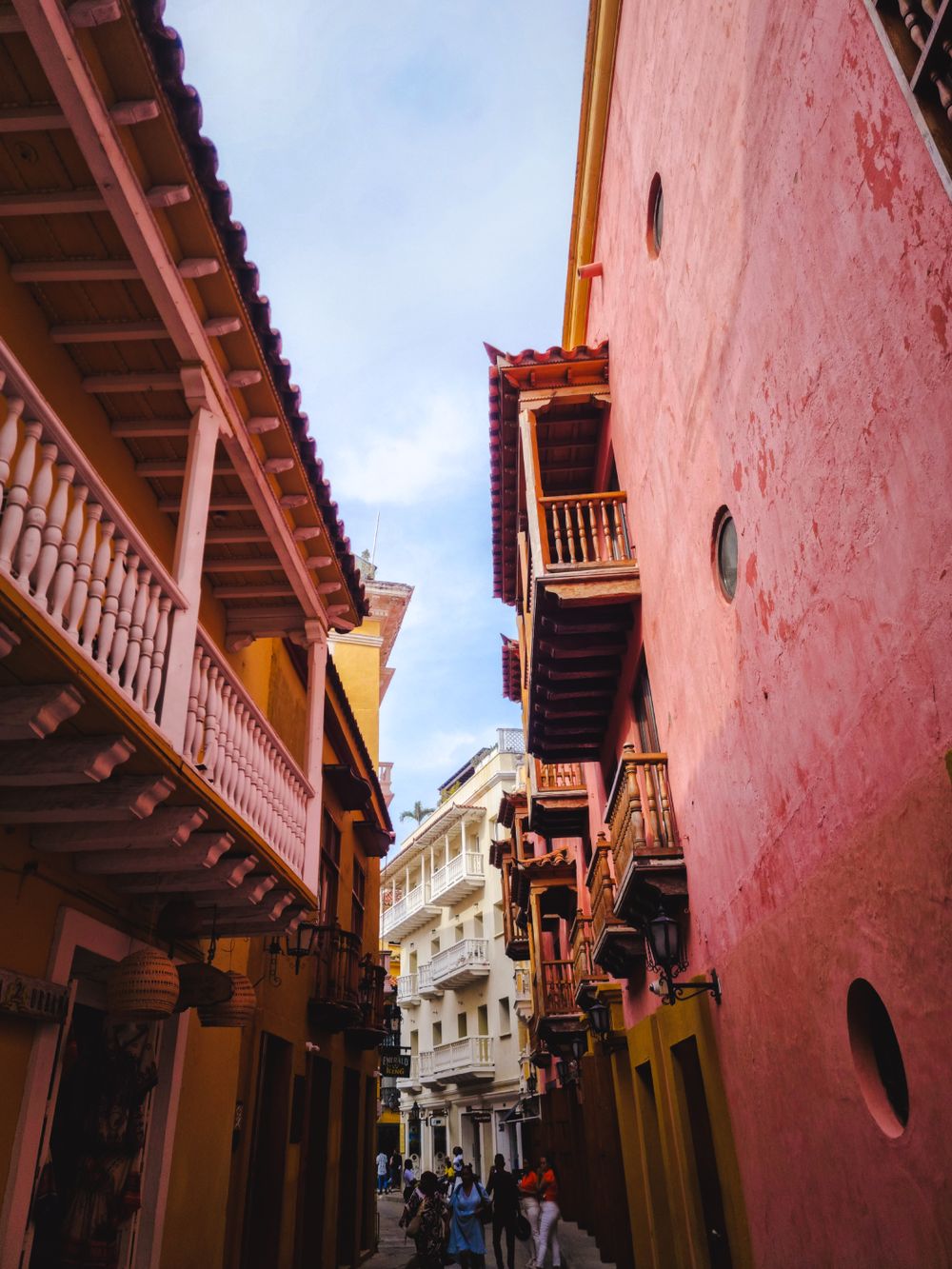 Calle colonial de Cartagena con balcones de madera entre paredes rosadas y ocres