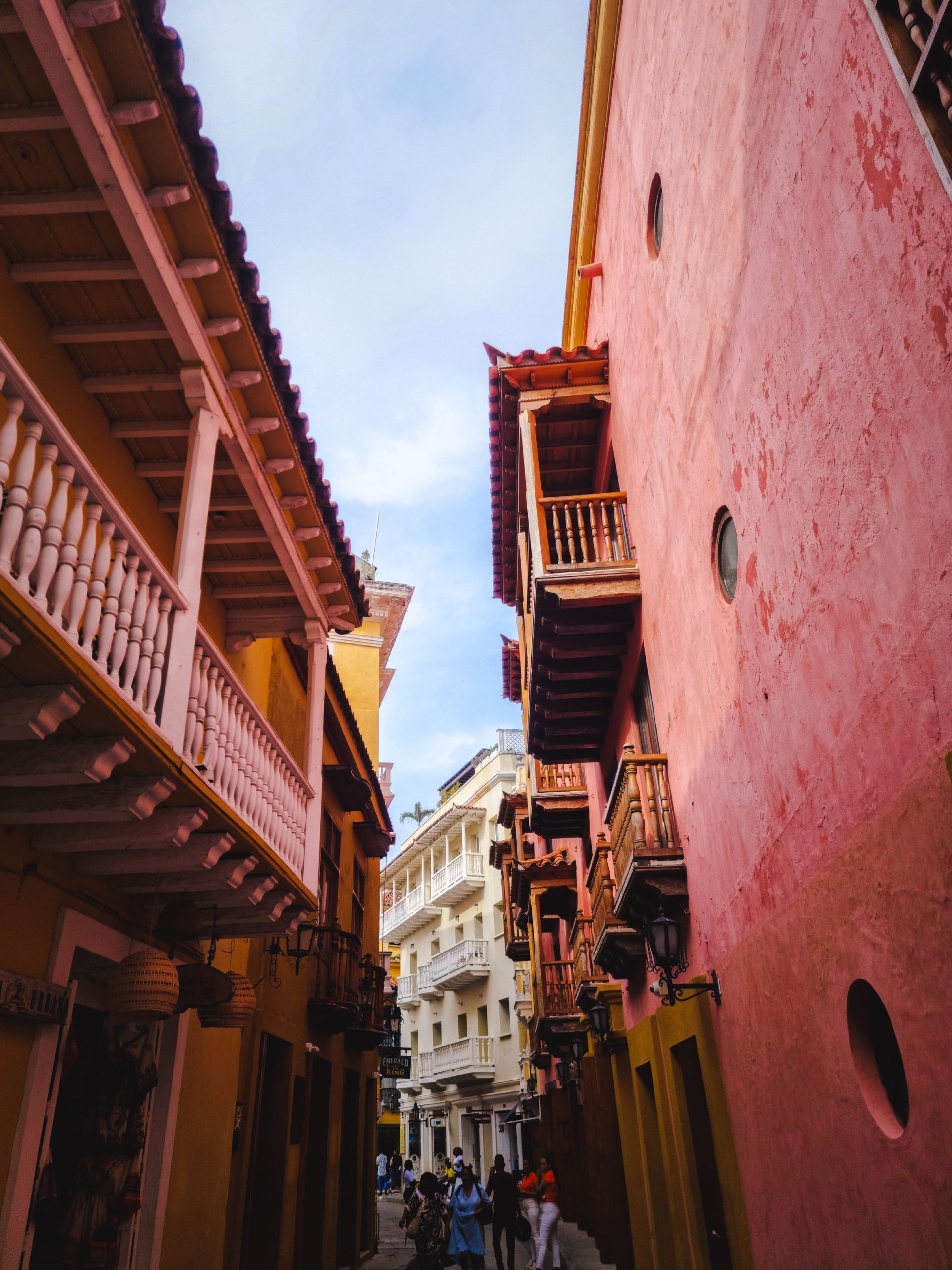 Calle colonial de Cartagena con balcones de madera entre paredes rosadas y ocres