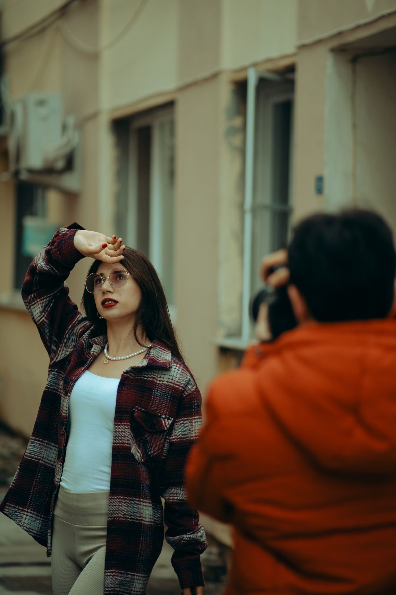 Woman in a red plaid shacket posing during an outdoor photo shoot
