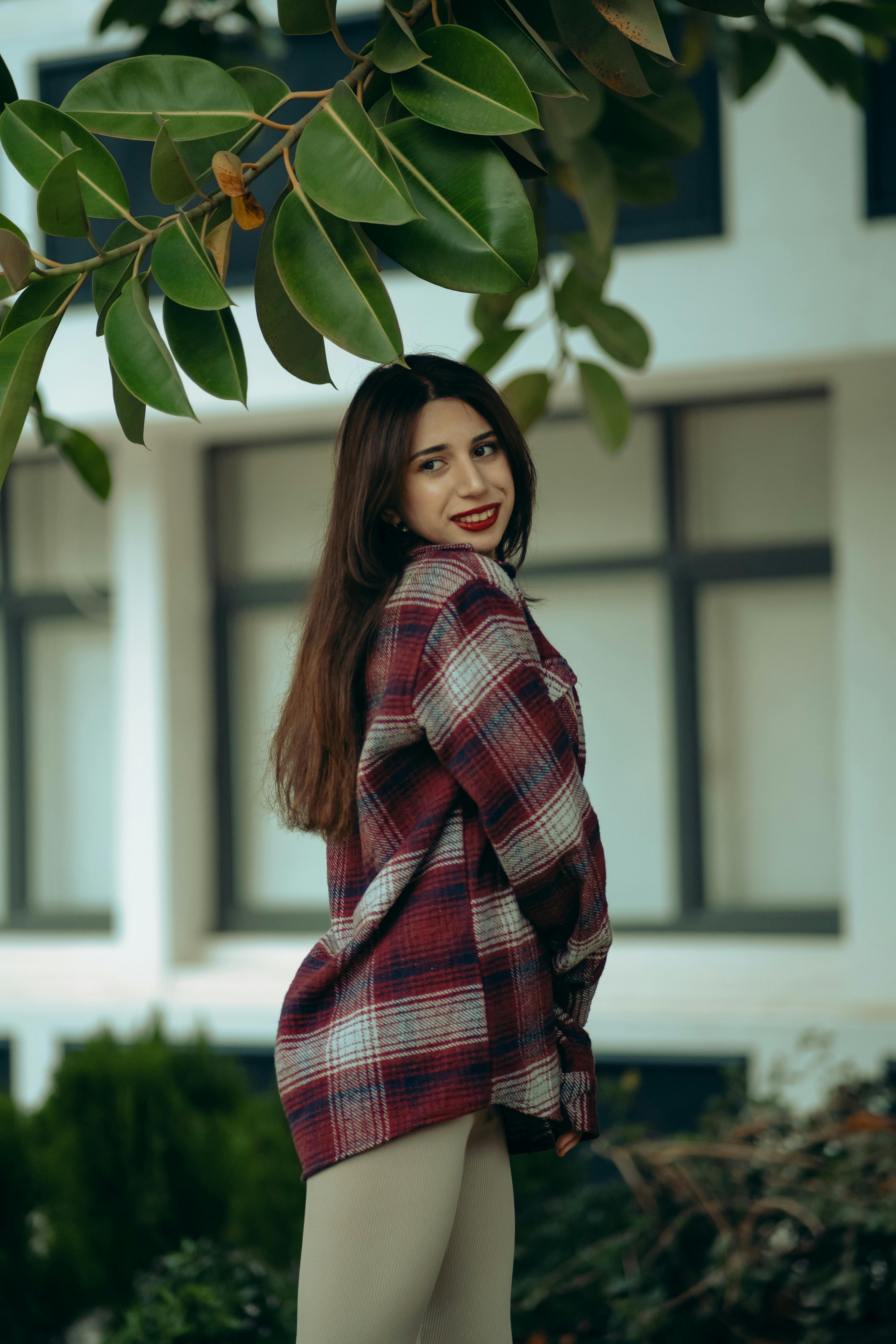 Young Woman in Flannel Blouse and Leggings Under a Tree Branch
