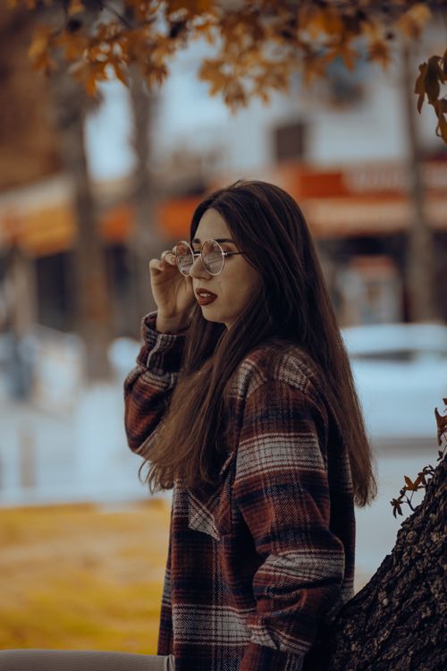 Free Stylish woman in fashionable fall attire with glasses in an outdoor setting. Stock Photo