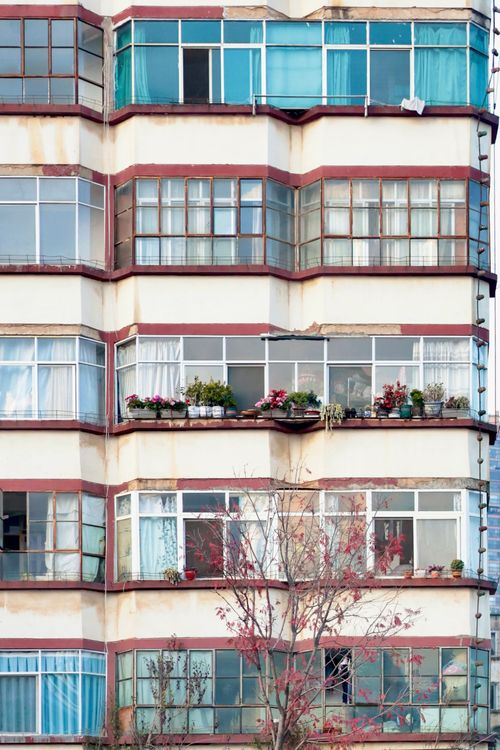 Free A close-up view of an apartment building's balconies adorned with plants and flowers. Stock Photo