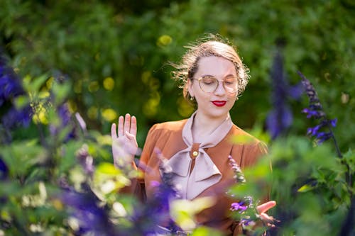 Woman in Eyeglasses Standing among Flowers