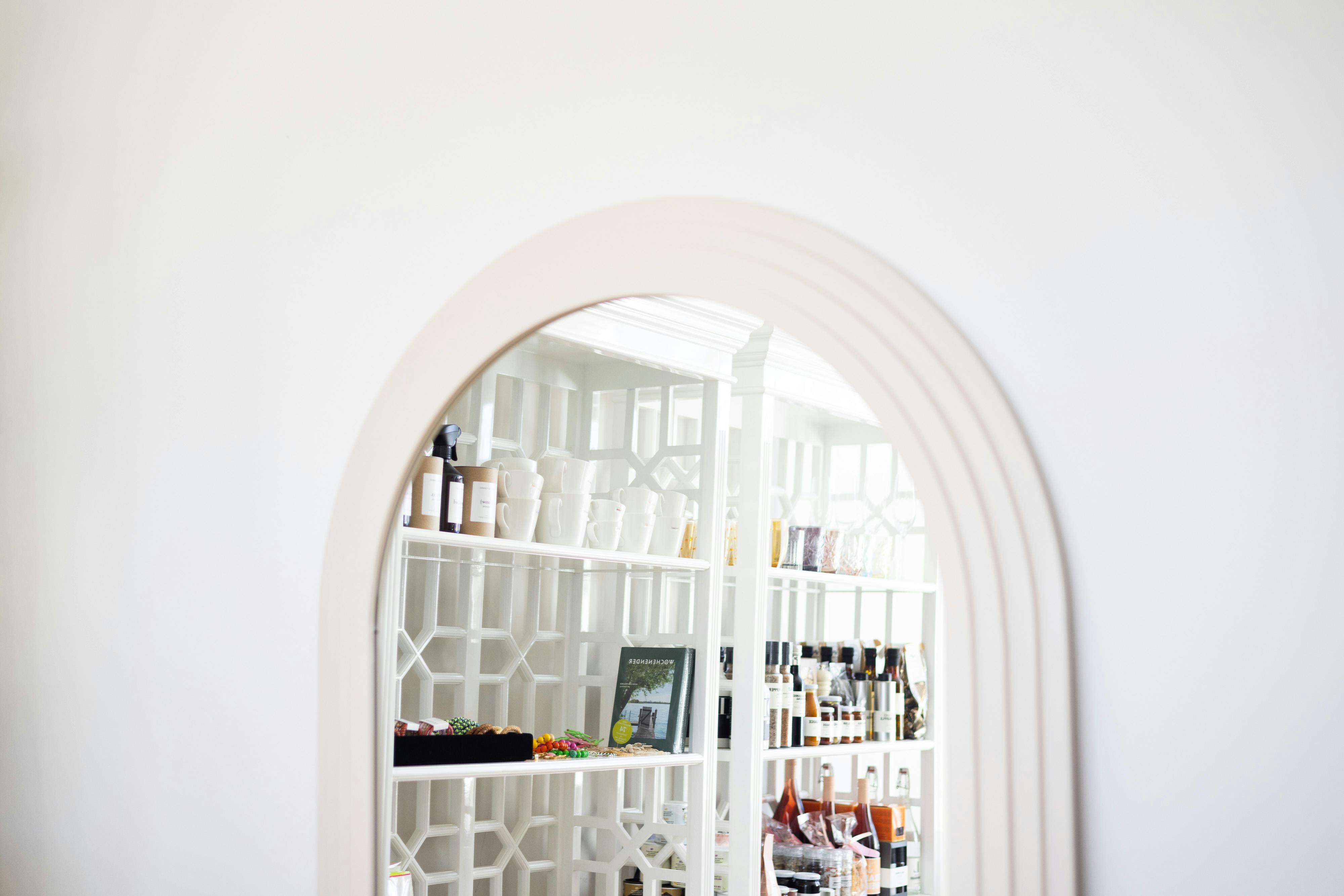 Person standing on a display ladder in a disorganized living room with tidy storage solutions