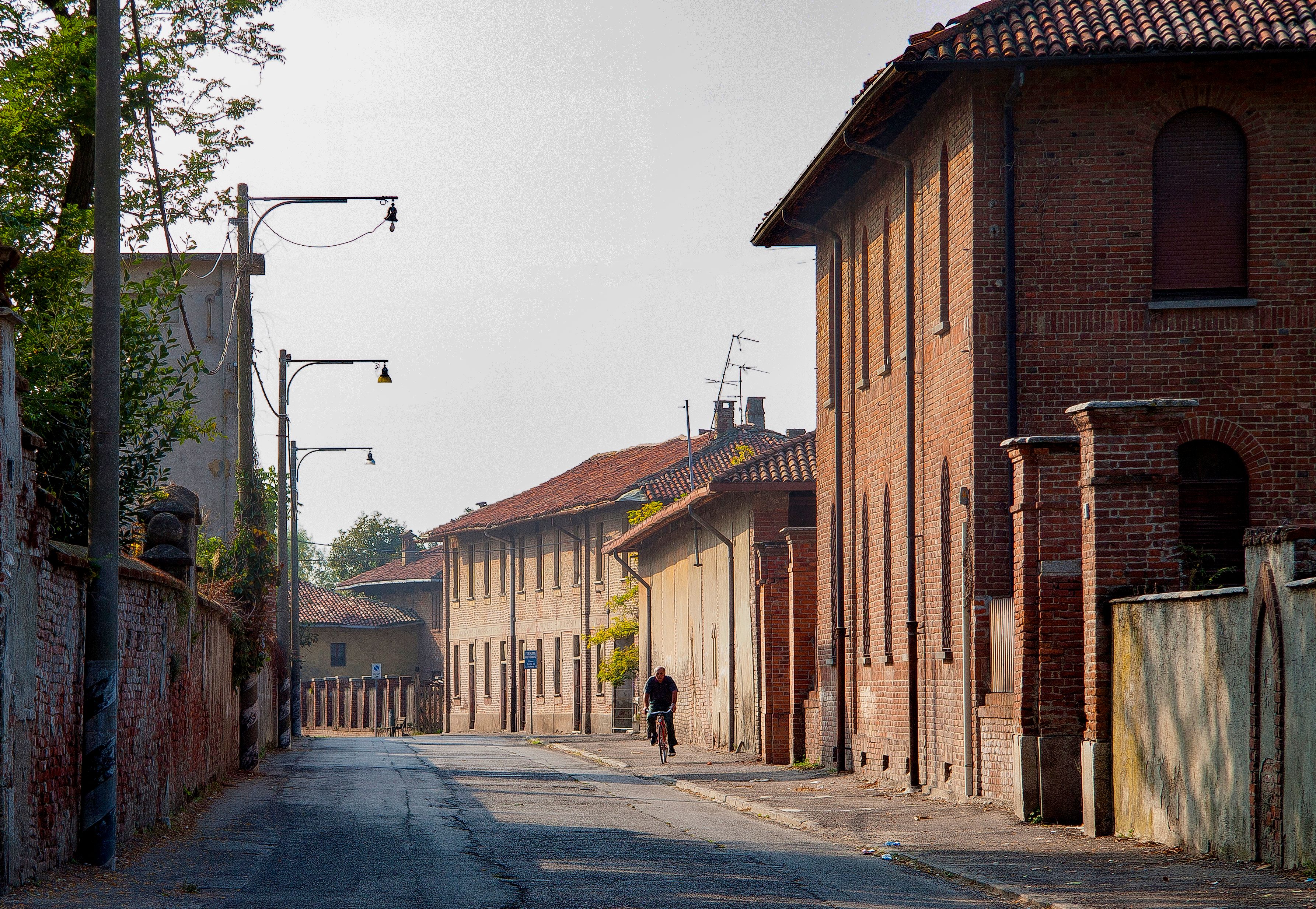 Peaceful urban street view featuring vintage brick buildings under a clear sky.