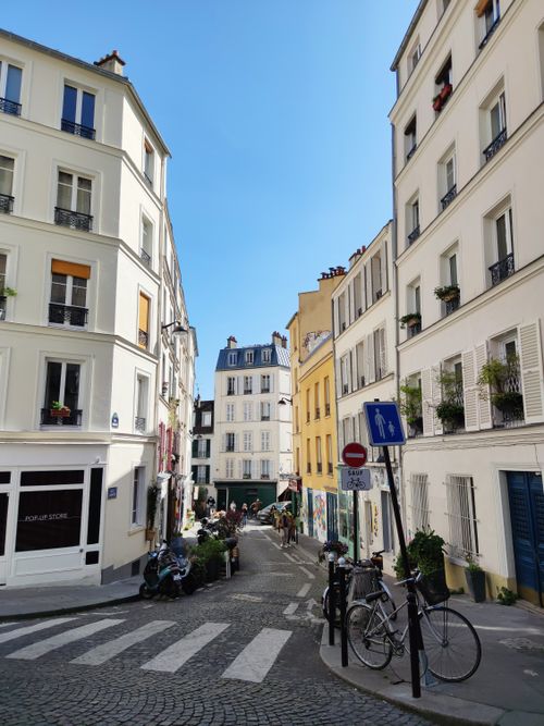 Free A quaint street in Montmartre, Paris, with traditional buildings and a sunny atmosphere. Stock Photo