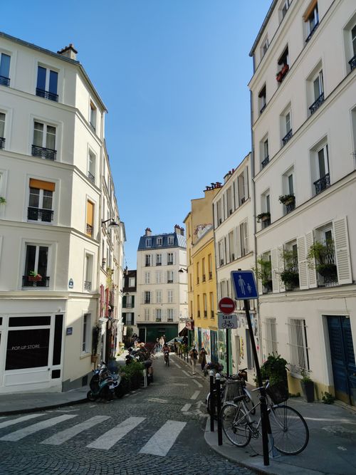Free Explore a picturesque Parisian street with charming architecture and cobblestone paths. Stock Photo