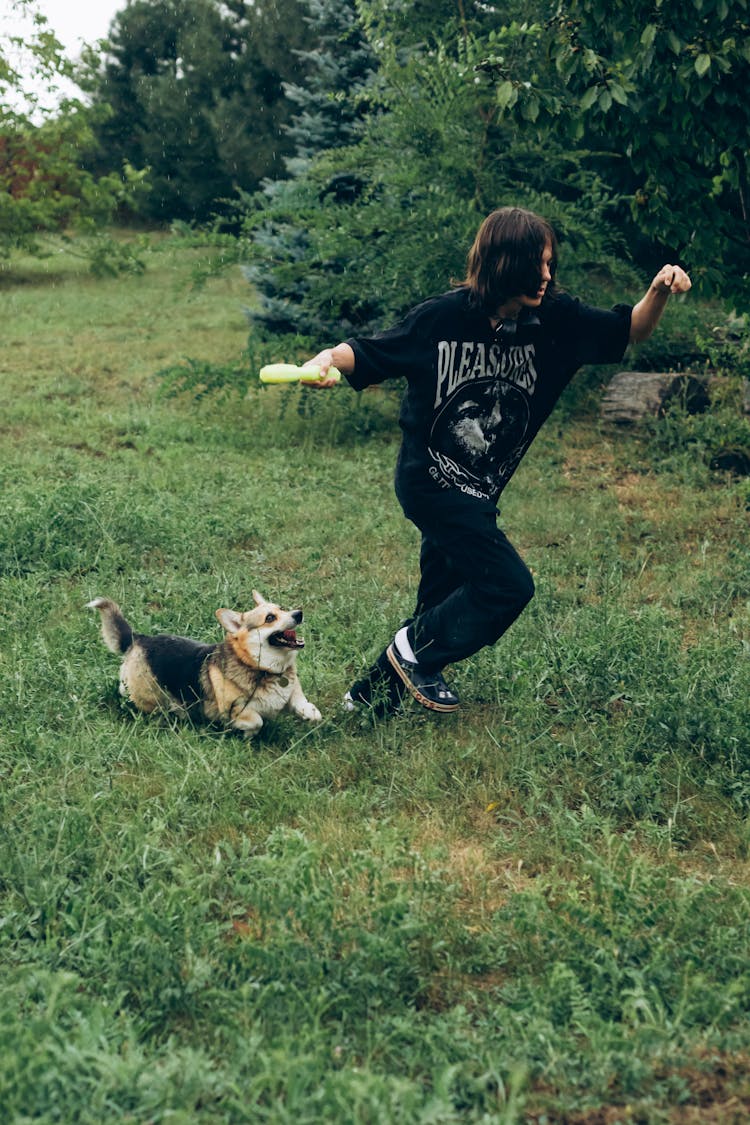 Teenager Playing With His Dog In The Yard