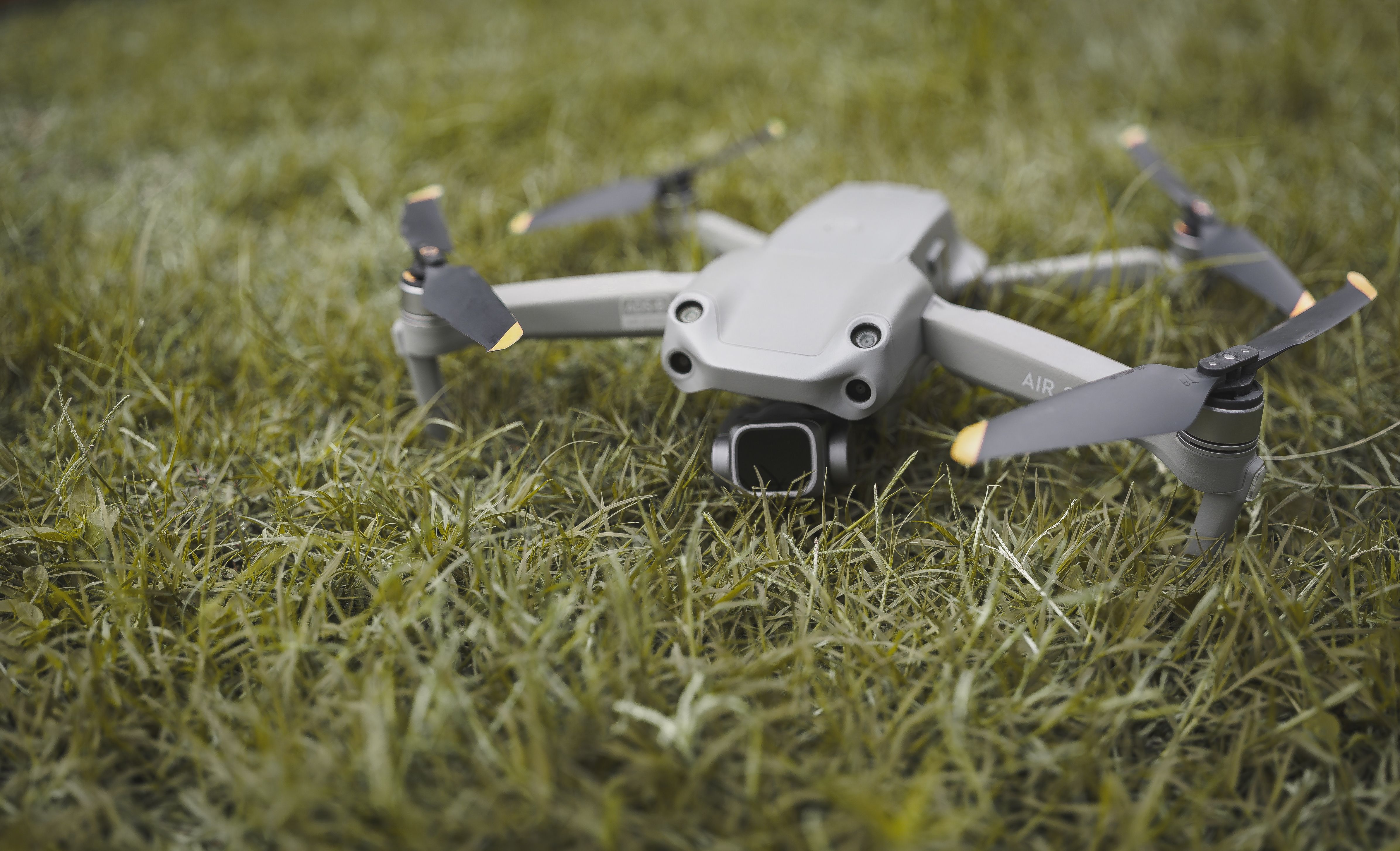 Close-up photo of a drone resting on a grass field in Zambia, showcasing outdoor technology.