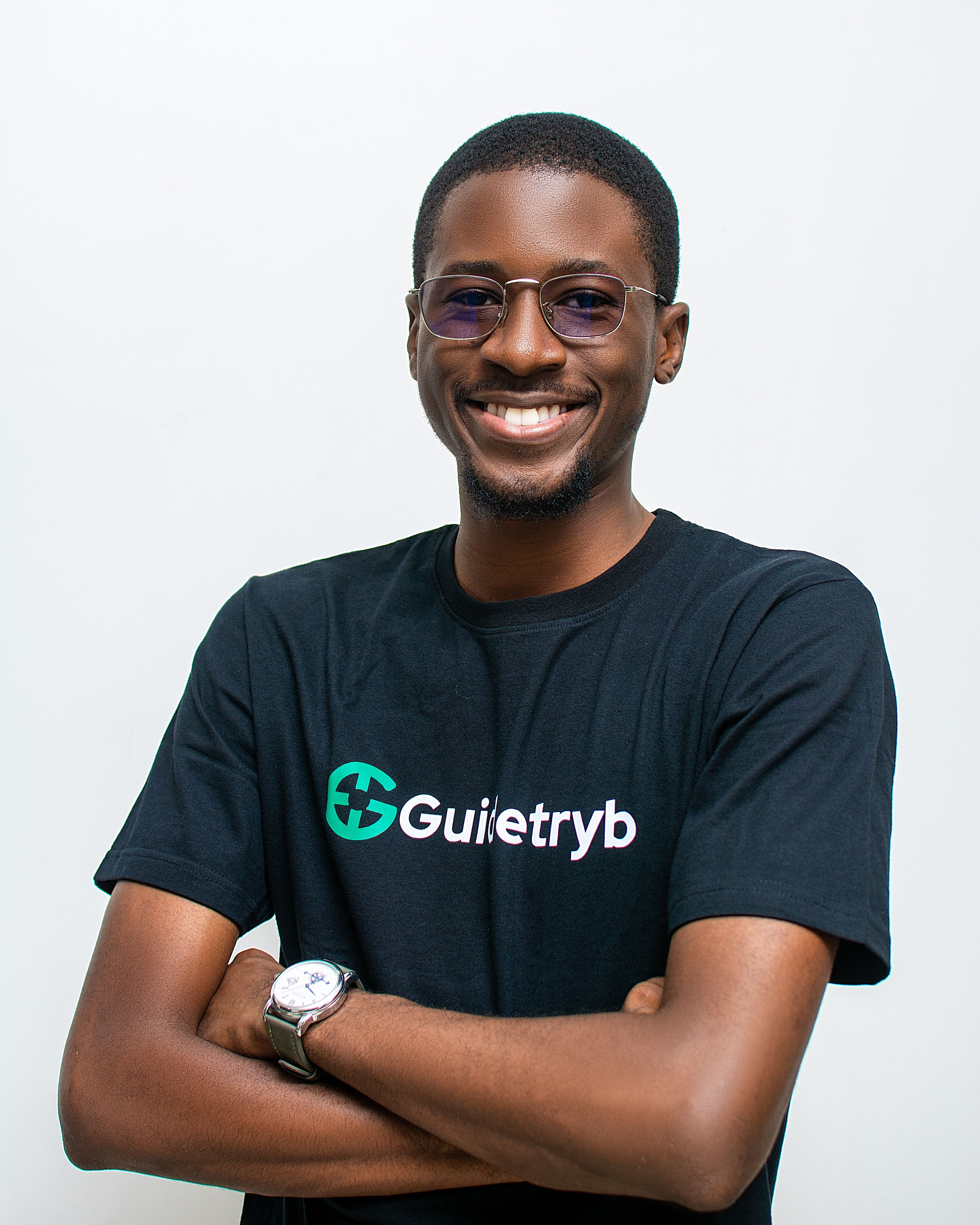 Portrait of a smiling man in a black t-shirt with eyeglasses on a white background.