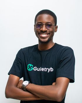 Portrait of a smiling man in a black t-shirt with eyeglasses on a white background.