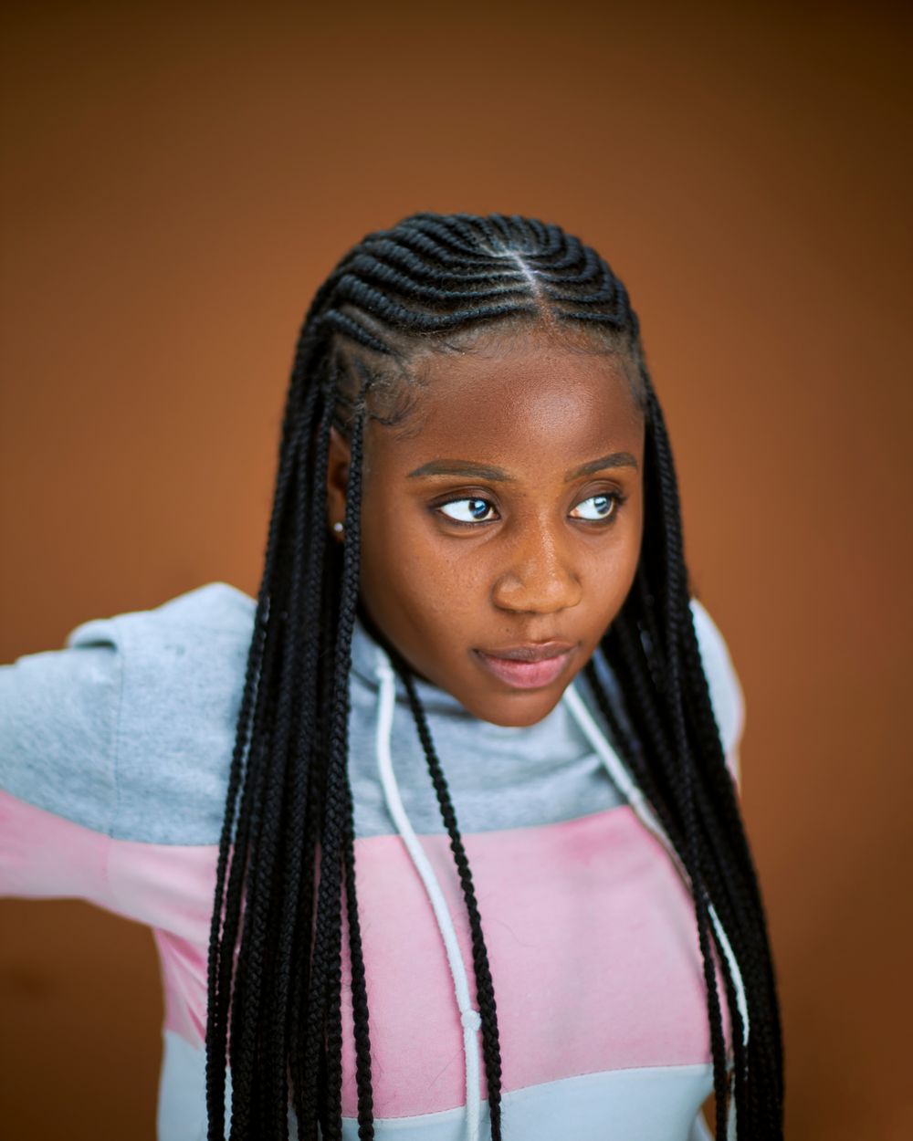 Studio portrait of a young woman with long braided hair. Photo: Boko Shots on Pexels Studio portrait of a young woman with long braided hair
