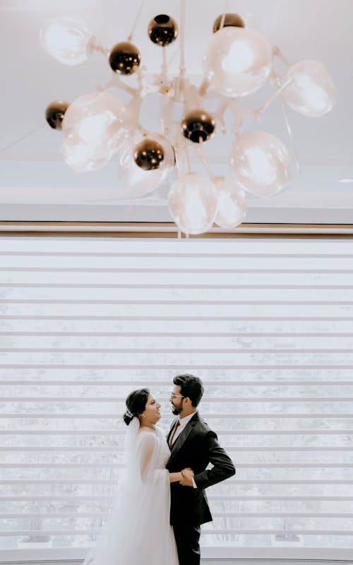 Newlyweds Standing Together under Lamp
