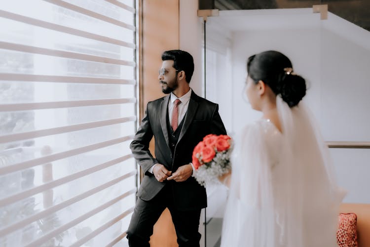 Bride And Groom Standing By The Window